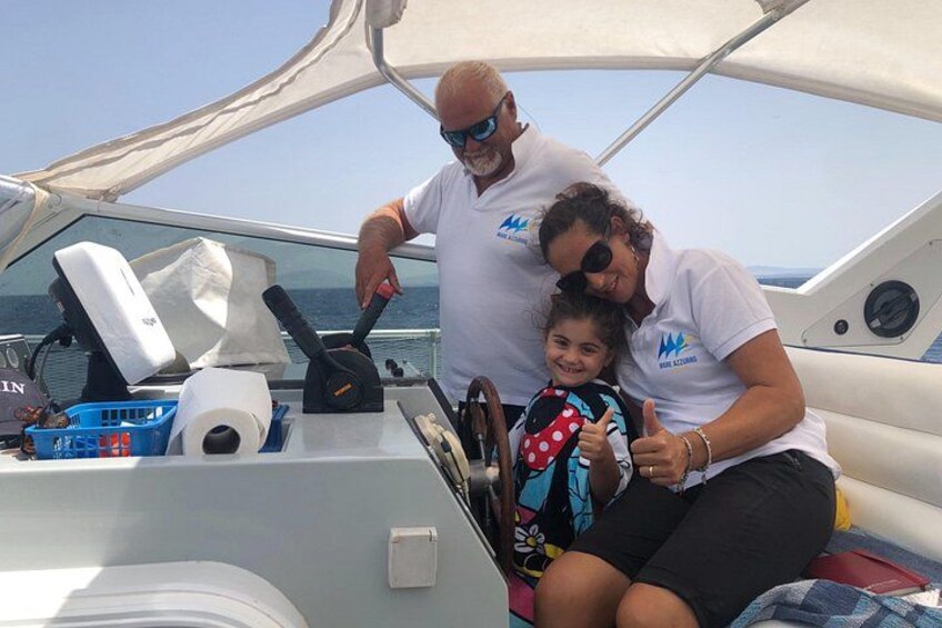 Un bateau avec une personne aux commandes, un enfant portant un gilet de sauvetage et une femme assise. 4