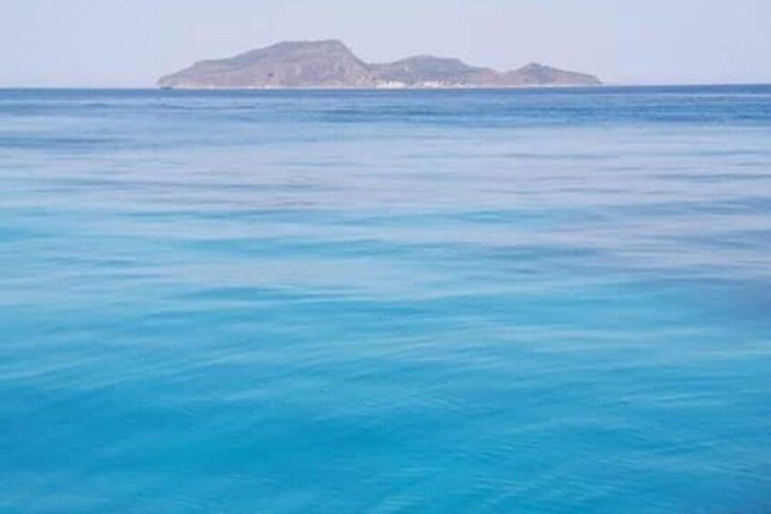 Une mer calme avec une petite île à l’horizon. 4
