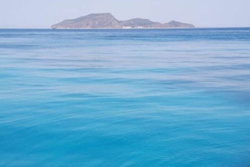 Mar tranquila con una isla a lo lejos. 3