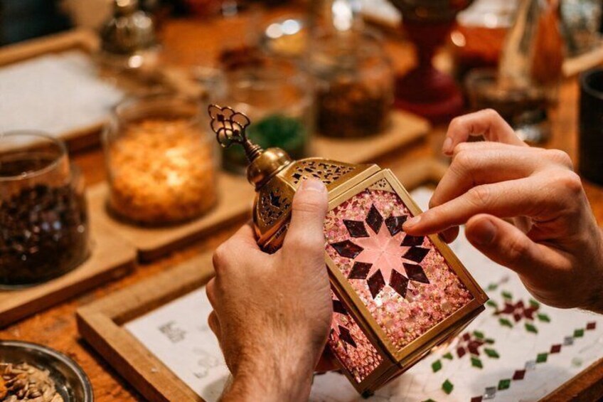 Hands assembling a decorative box with a star pattern. 5