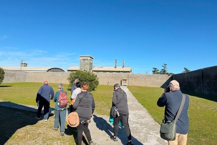 Un grupo de personas caminando por un sendero de hormigón hacia un edificio con una torre. 3