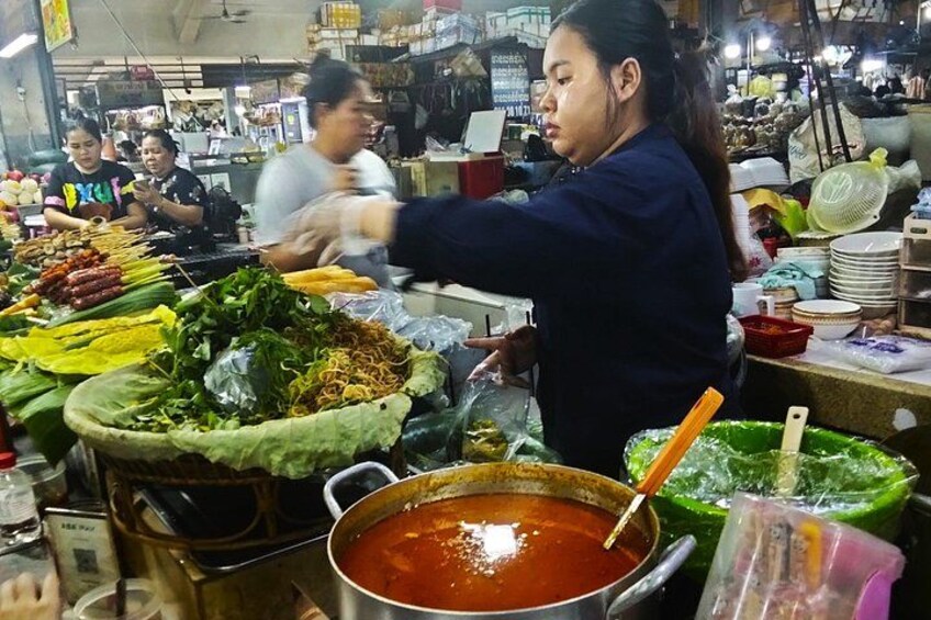 Escena de mercado con diversos alimentos y una persona sirviendo comida. 3