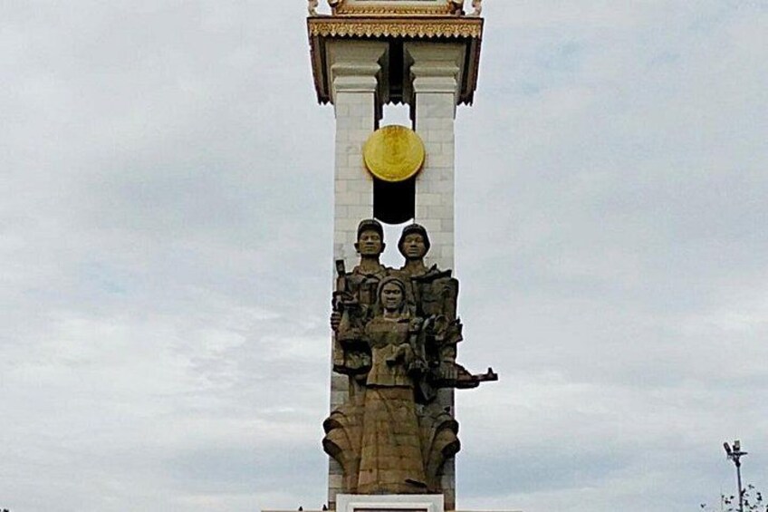 Un monumento grande con estatuas, un emblema circular y una estructura blanca en la parte superior. 5