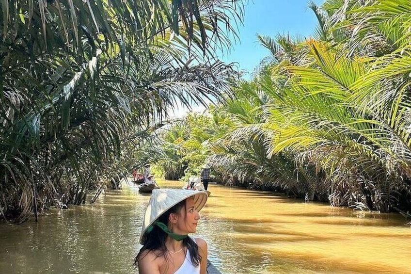 A river surrounded by palm trees with a boat in the distance. 4