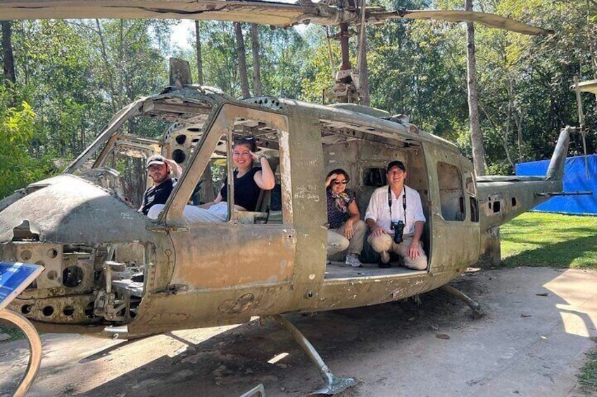 A helicopter with four people inside, parked outdoors. 2