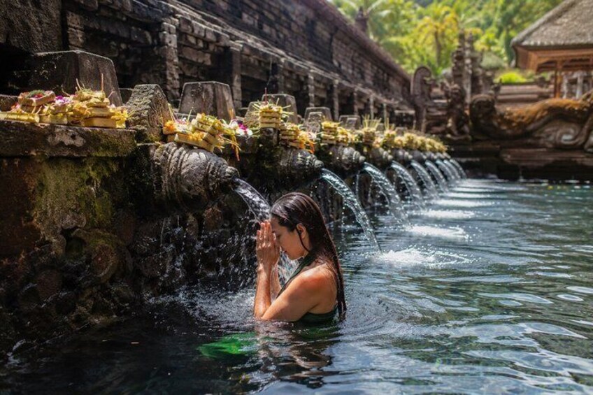 Eine Person im Wasser, mit einem Wasserfall und Steinformationen. 3