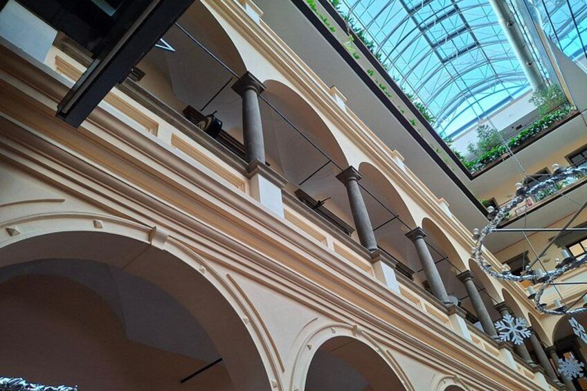A multi-level atrium with arches, columns, and a glass ceiling. 2