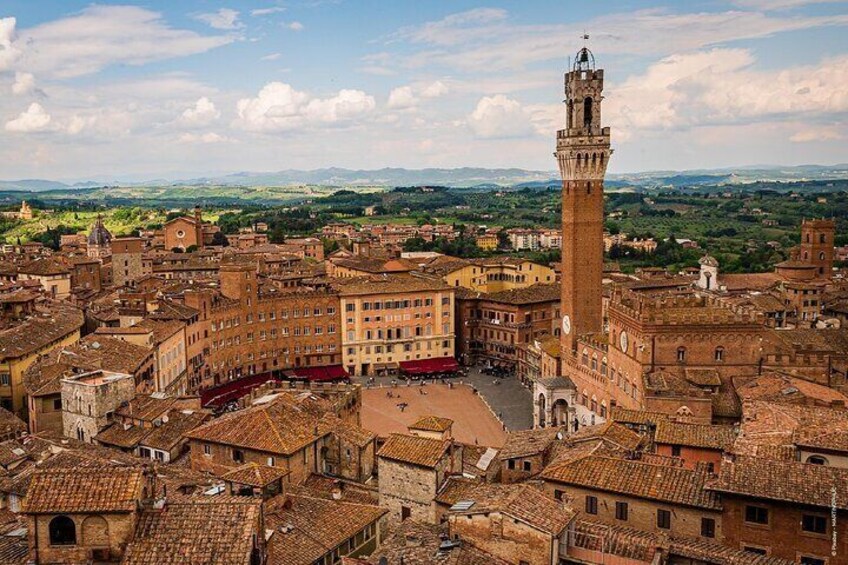 A historic town with a prominent tower and terracotta-roofed buildings. 3
