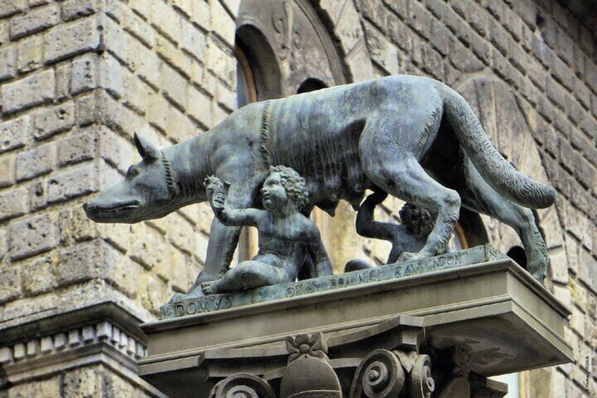 A bronze statue of a bull and a man on a building. 2