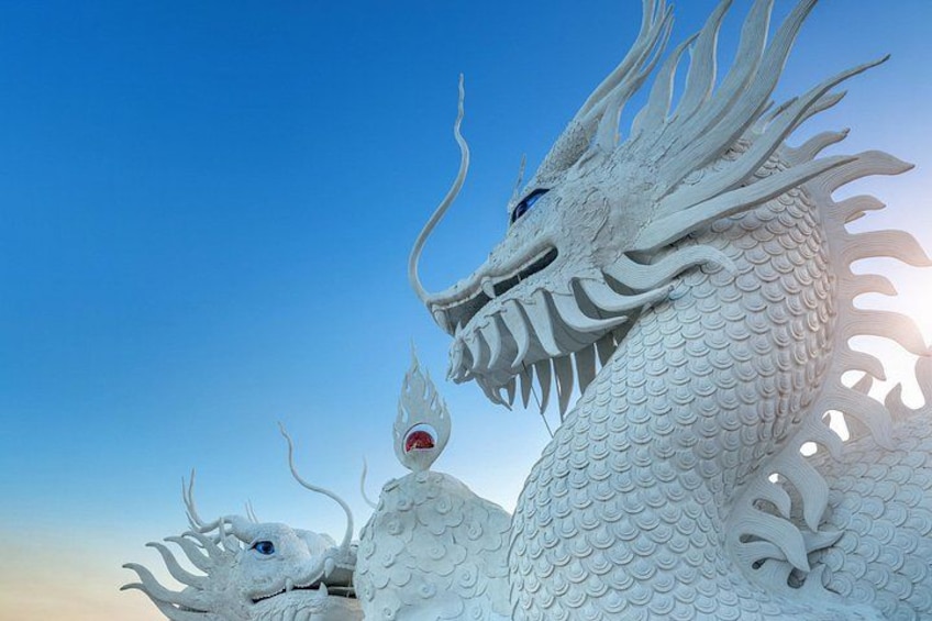 Una gran escultura de dragón blanco con escamas detalladas y una expresión amenazante. 4