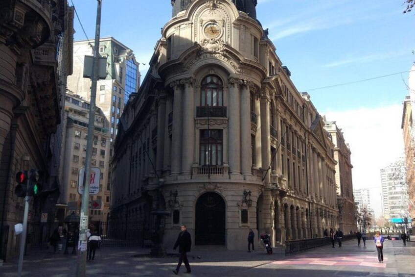 Ein historisches Gebäude mit aufwendiger Architektur, einer großen Uhr und einer Fußgängerampel. 2