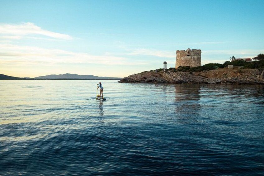Una persona fa paddleboarding vicino a una torre storica in riva all'acqua. 4