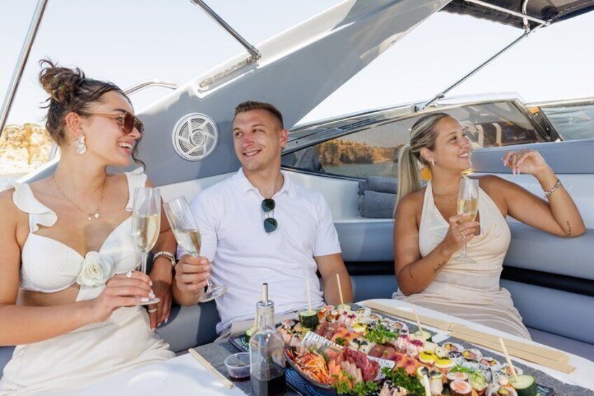 Tres personas en un bote, con una bandeja de mariscos y bebidas. 4