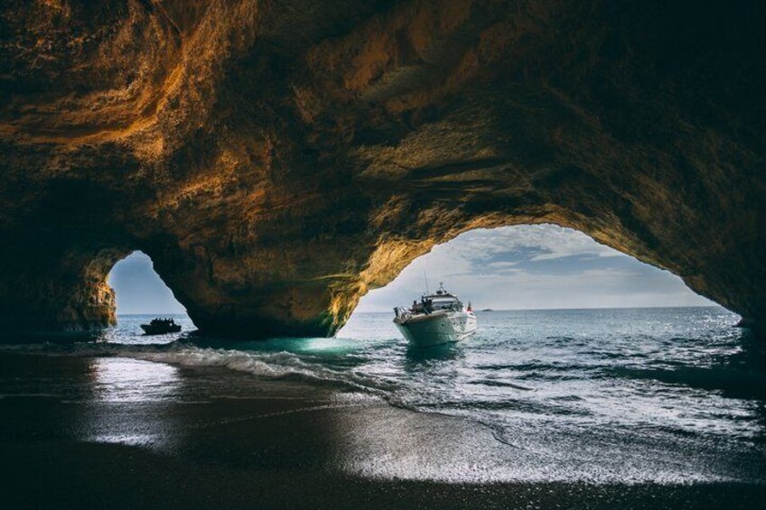 Una embarcación navegando bajo un arco de roca natural sobre el océano. 2