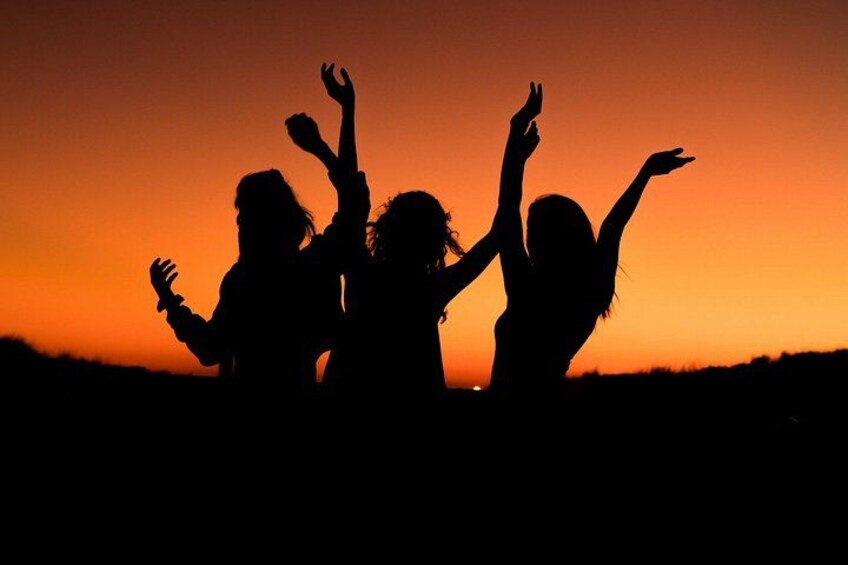 A silhouette of three people against a sunset sky. 5