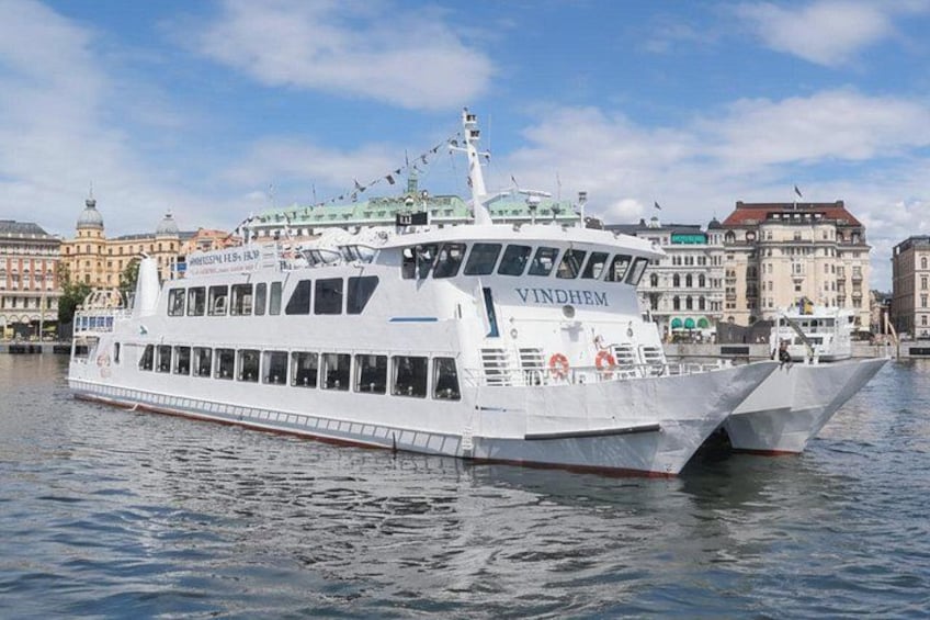 A white cruise ship named VINDHEM docked at a harbor with buildings in the background. 3