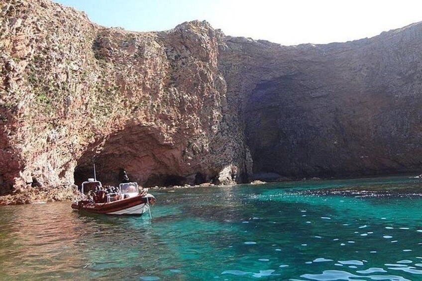 Un bateau est amarré près d’une côte rocheuse, dans une eau turquoise et cristalline. 3