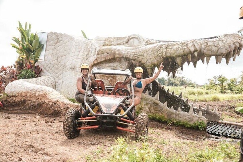 Un jeep frente a una gran escultura de cocodrilo. 1
