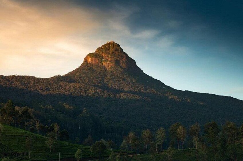 A mountain with a prominent peak, surrounded by a forested landscape. 1