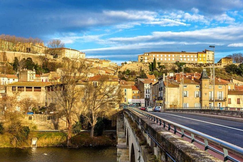 A river with a bridge, buildings, and a hill with a castle-like structure. 5