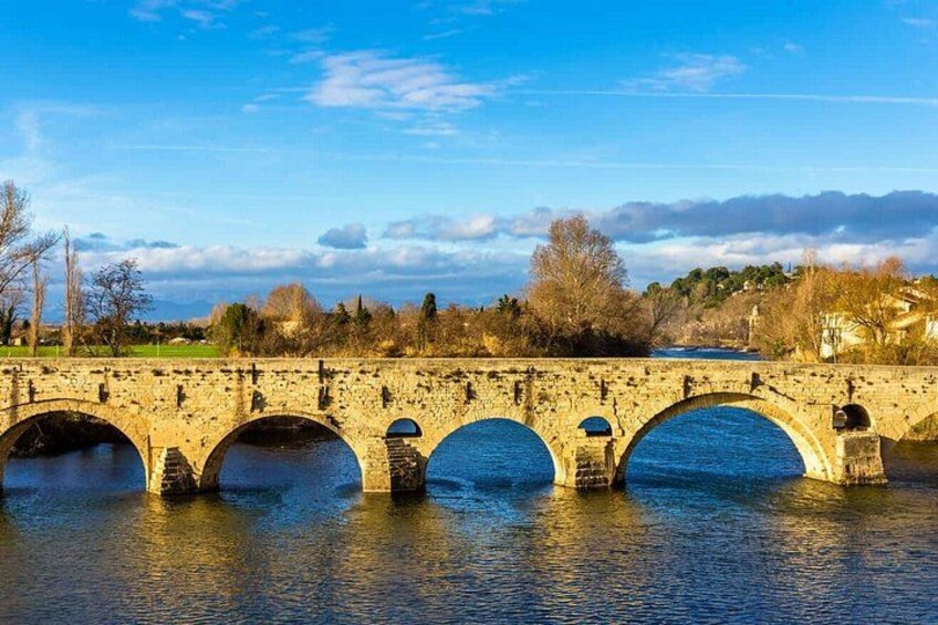 A stone bridge with multiple arches over a river. 2