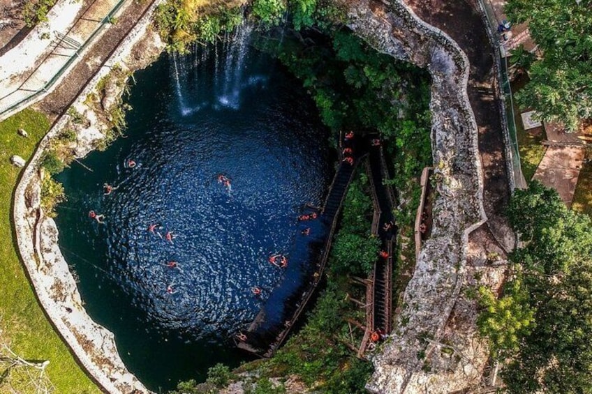 Une étendue d’eau circulaire, bordée d’un sentier rocheux et de végétation. 2