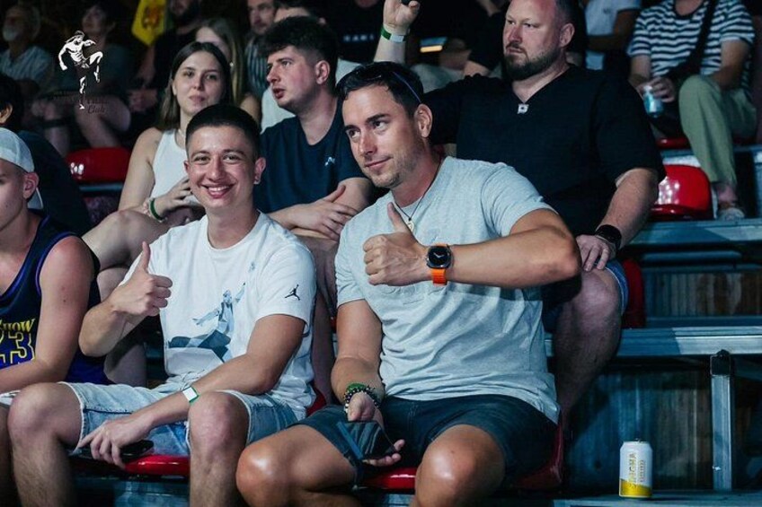 People seated in a stadium with a watch on one wrist. 2