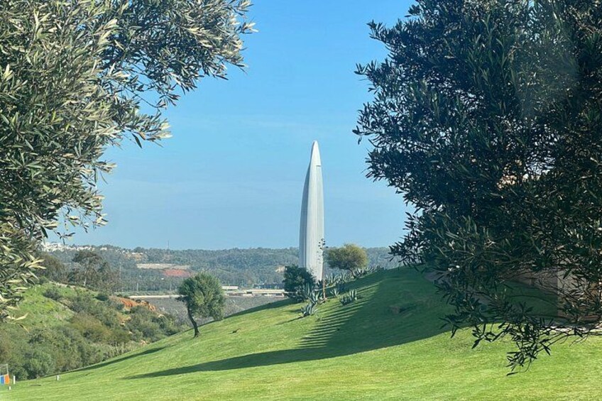 A monument on a grassy hill with trees around it. 5