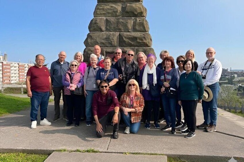 A group of people standing in front of a large stone monument. 5