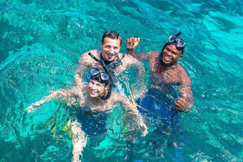 Three people snorkeling in clear blue water. 2