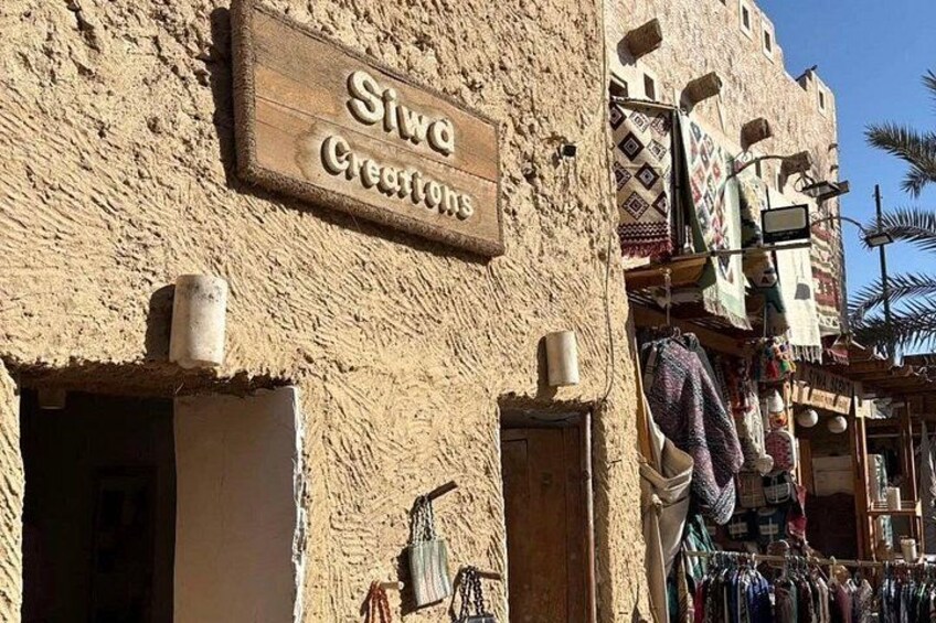 A building with a sign reading 'Swa Creations' and a shop with colorful fabrics. 4