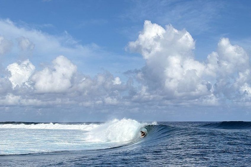 Un surfista cabalgando una ola en el océano, con cielo despejado y nubes. 1