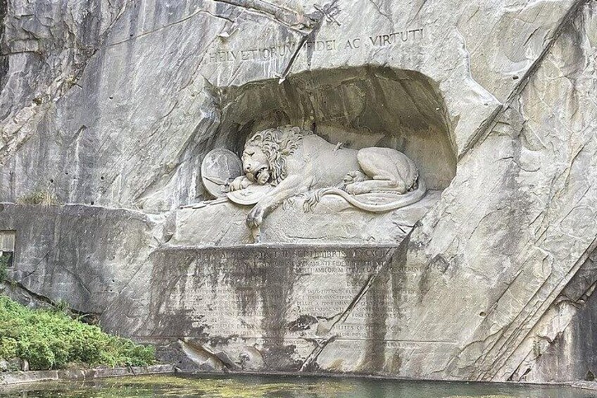 Relieve pétreo de un león dormido con inscripciones en un risco. 2