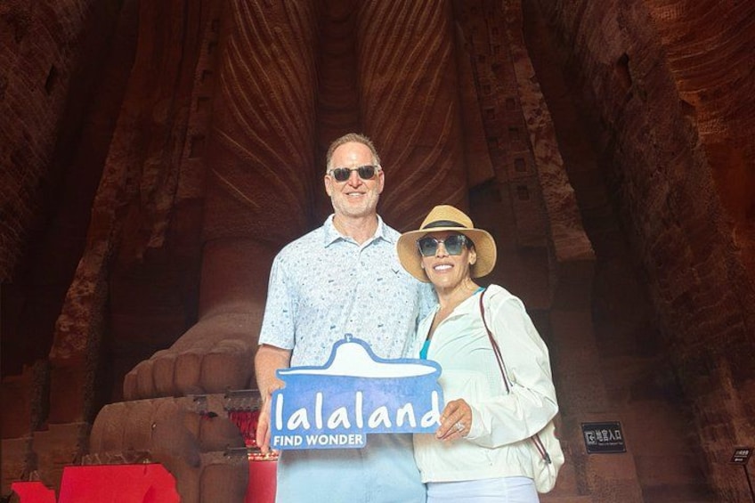 Two people standing in a canyon with a sign that reads 'lalaland FIND WONDER'. 3