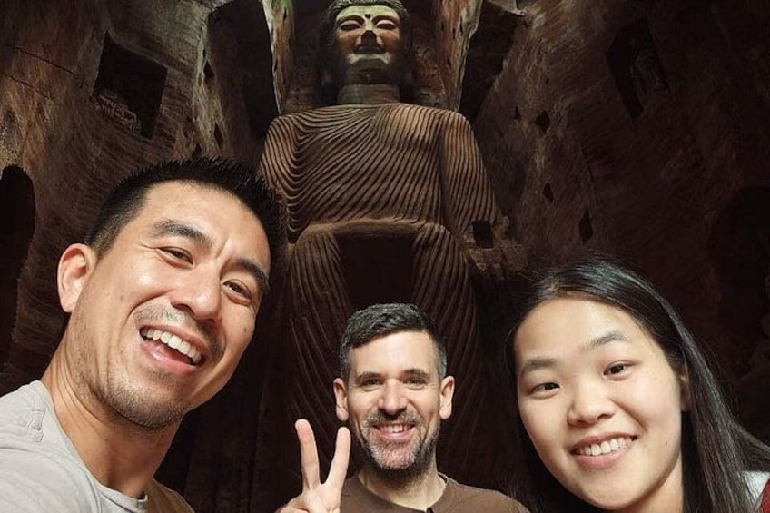 A group of people in front of a large, ancient stone structure. 1
