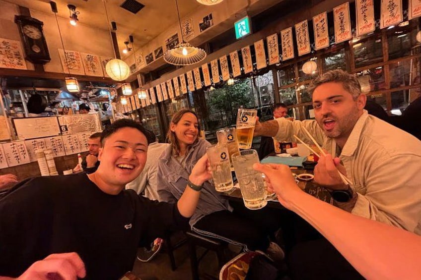 Un grupo de personas brindando con bebidas en un restaurante con decoración tradicional. 2
