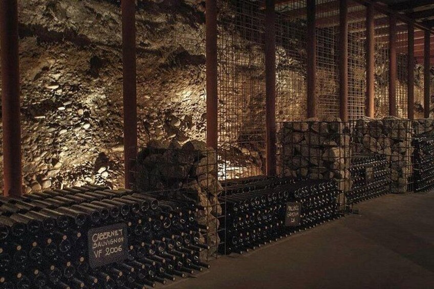 A cave with stone walls and metal railings, illuminated by artificial lighting. 3