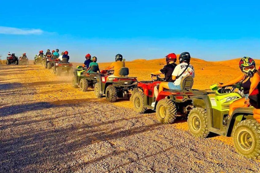 Un groupe de personnes circulant en quads sur un chemin de terre dans un paysage désertique. 2