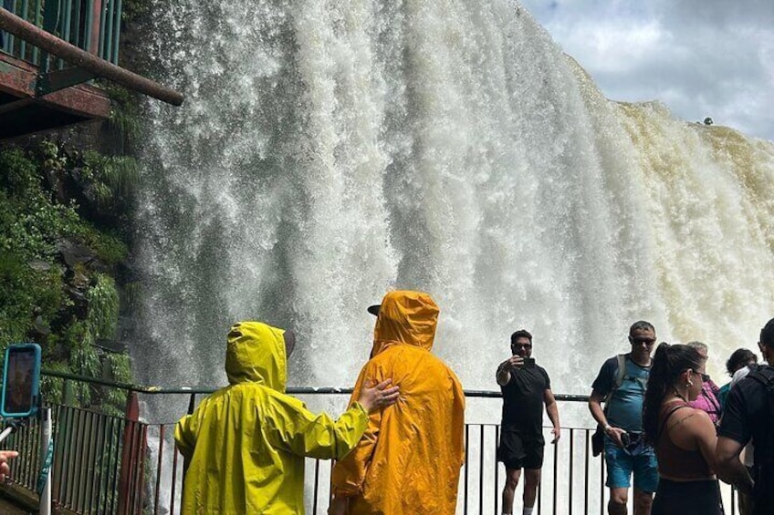 Una cascada con personas detrás de una cerca, vestidas con abrigos impermeables. 2