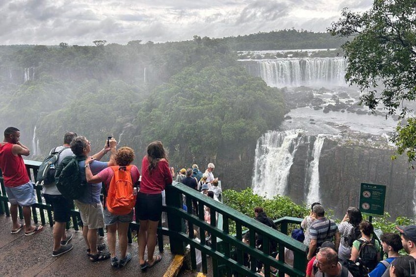 A waterfall with people observing it from a viewing platform. 1