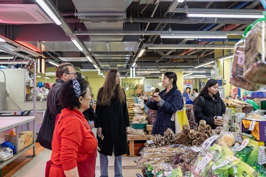 People shopping in a market with various goods on display. 3