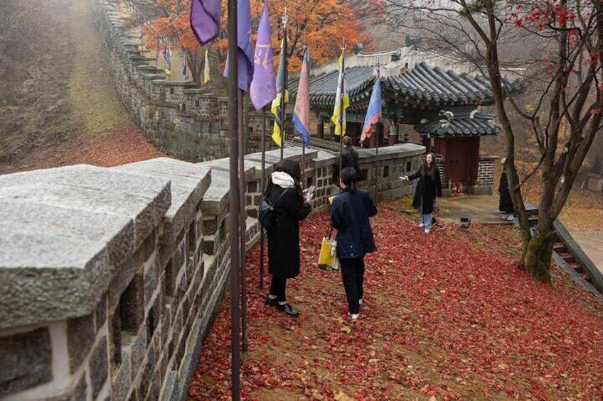 En stenmur, traditionell koreansk arkitektur och höstlöven. 5