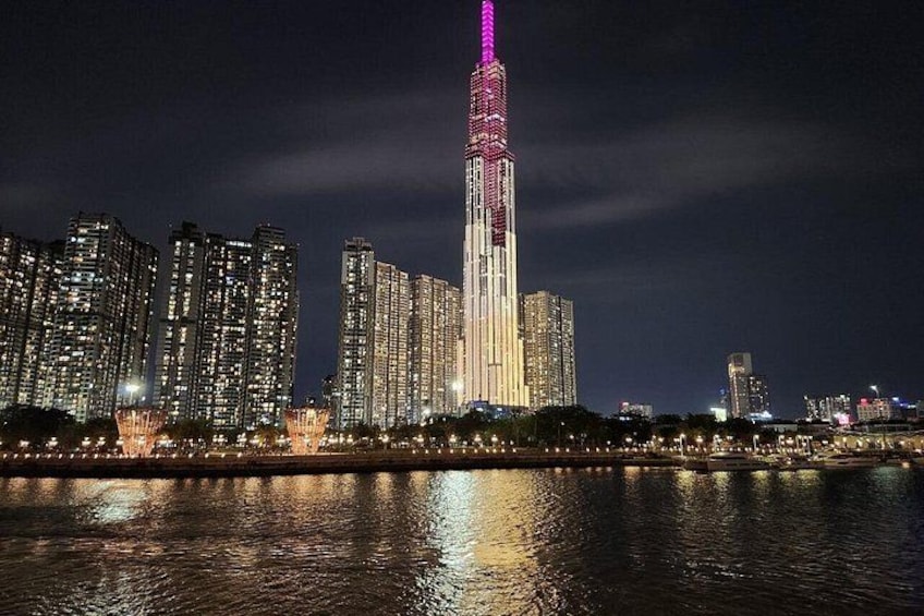 Lo skyline di una città di notte, con una torre illuminata da luci rosa e bianche. 4
