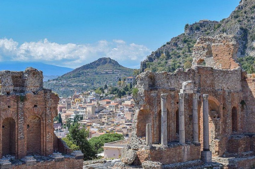 Des ruines antiques avec des colonnes, une vue sur la ville en arrière-plan et une montagne. 3