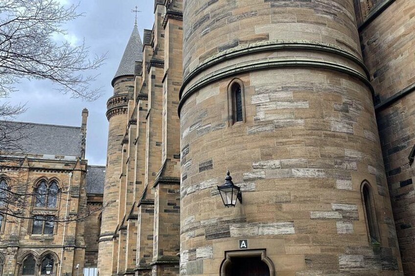 Een historisch gebouw van natuursteen met rondboogvensters en een toren. 5