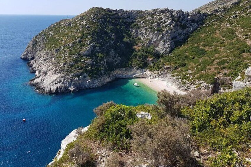 Un paysage côtier avec une falaise rocheuse, une plage et des eaux turquoise. 3