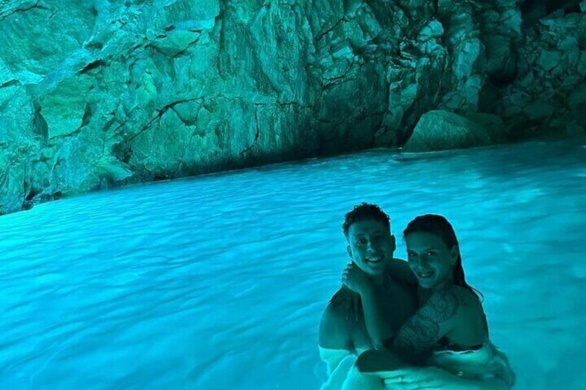 Deux personnes dans une grotte où l’eau est d’un bleu turquoise. 1