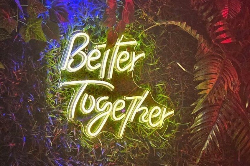 A neon sign with the text 'Better Together' surrounded by foliage. 4