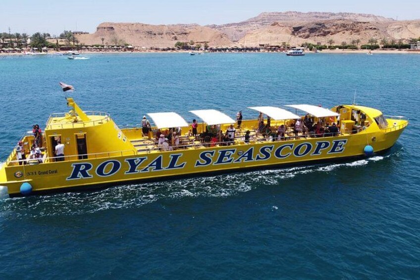 A yellow boat named 'ROYAL SEASCAPE' with passengers and a mountainous landscape in the background. 3