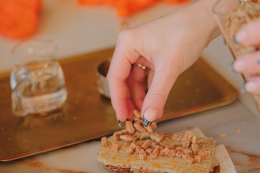A hand placing a small container on a tray. 2